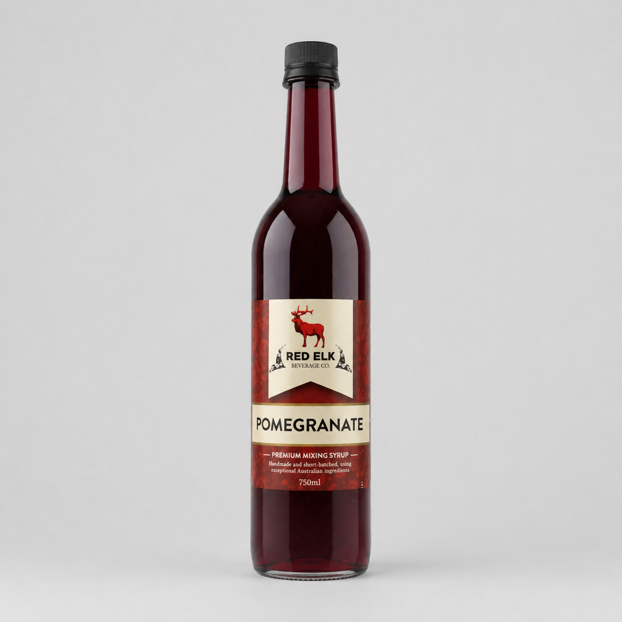 Bottle of Red Elk Pomegranate syrup on a gray background