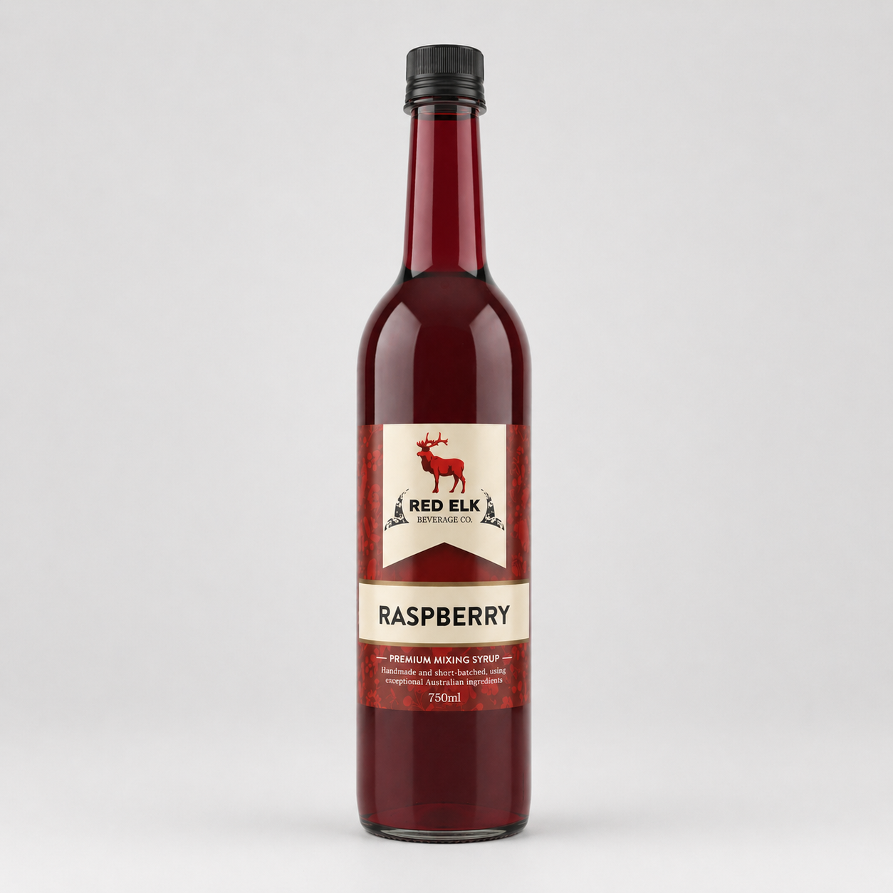 Bottle of Red Elk Raspberry syrup on a light gray background